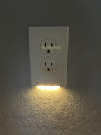 Light bulb inside a wall socket on a gray wall