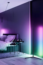 Modern bedroom with a large floor-standing lamp casting colorful light.